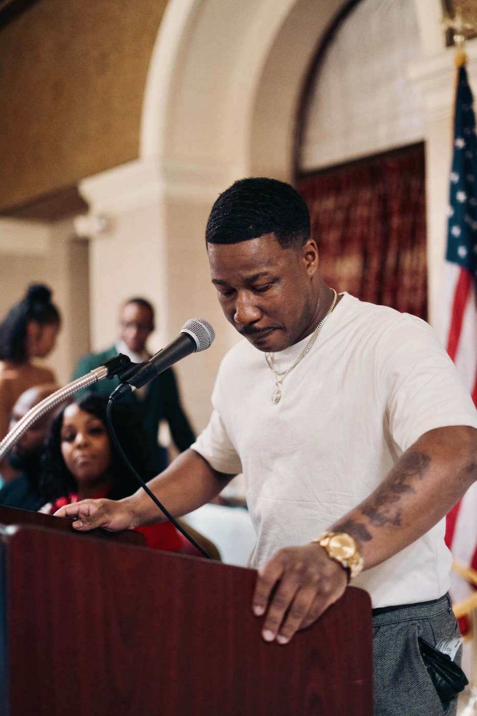 CJ Burnett speaking at a podium after receiving a City Council award.